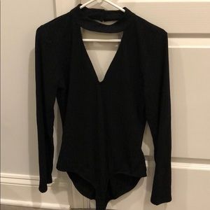 Form-fitting black long sleeve body suit